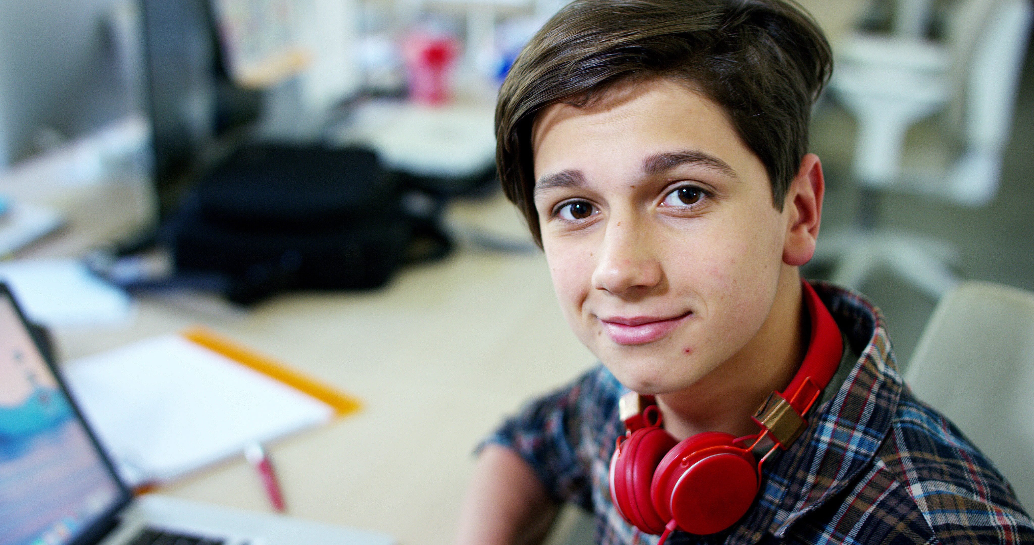 A boy smiling with his school supplies